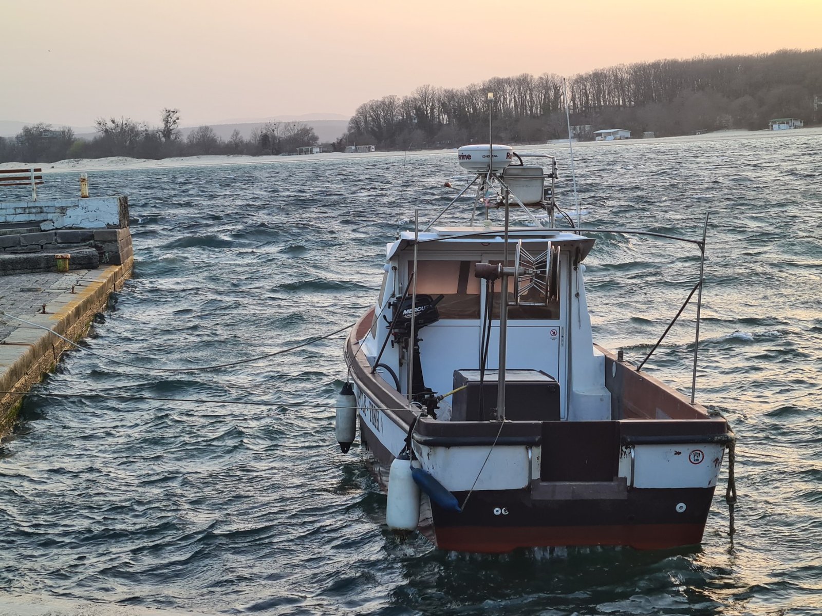 Лодка на буреното море при залез